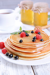 Sweet pancakes with berries on table close-up
