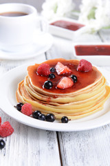 Sweet pancakes with berries on table close-up