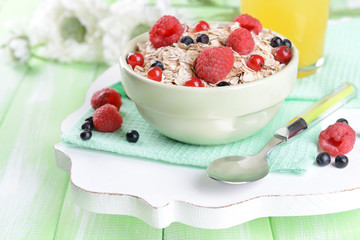 Tasty oatmeal with berries on table close-up