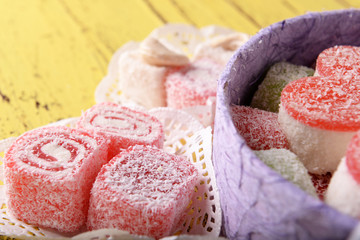 Present box with sweets on wooden background