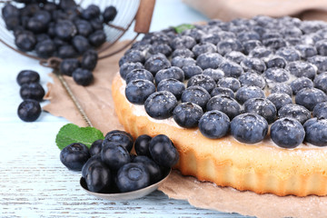 Tasty homemade pie with blueberries on wooden table