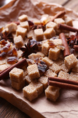 Brown sugar cubes and spices on paper background