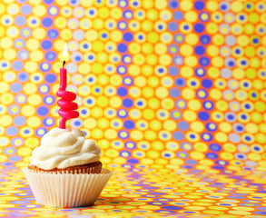 Delicious birthday cupcake on bright background