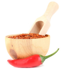 Milled red chili pepper in wooden bowl isolated on white