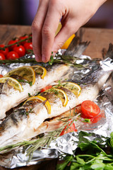 Tasty baked fish in foil on table close-up