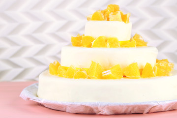 Beautiful wedding cake with oranges on  light background