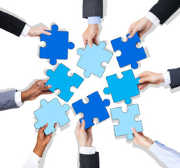 Group of Hands Holding Jigssaw Puzzle