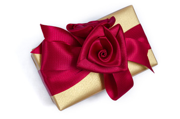 Gold box gift wrapped with a red ribbon
