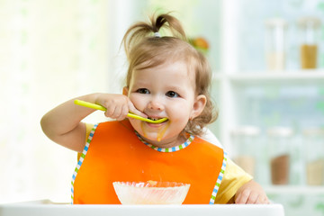 smiling kid eating food on kitchen