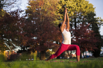 Asian chinese woman doing yoga in nature during sunset