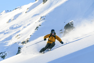 Skifahrer in Schnee-Staubwolke