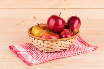 Fototapeta na wymiar Fresh red apples in basket on wood.