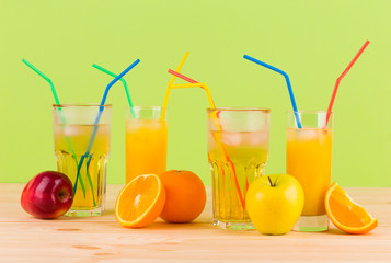 Orange and apple juices on wooden table.