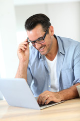 Portrait of mature man working at home with laptop