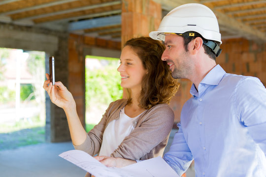 Young woman and architect on construction site