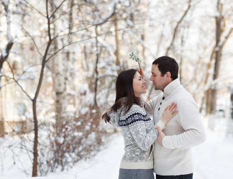 Happy Young Couple Under Mistletoe Having Fun