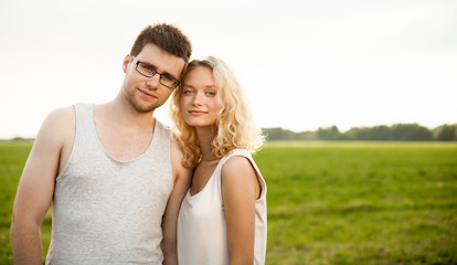 Happy Smiling Couple Relaxing on Green Grass.