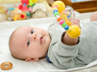 Infant boyl playoing with rattle - 70510980