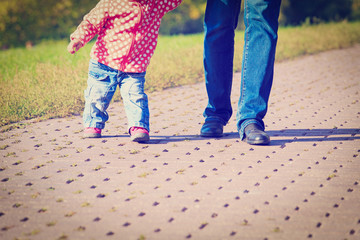 mother teaching little daughter to walk