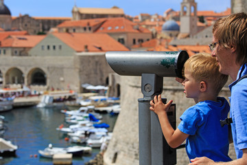 Obraz premium family looking through binoculars at the city