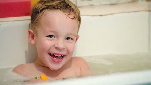 Happy Little Boy In Bath With Toys