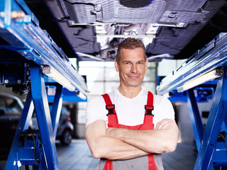 Car mechanic under a car
