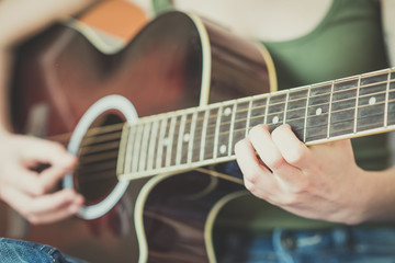 close up of woman hands playing guitar