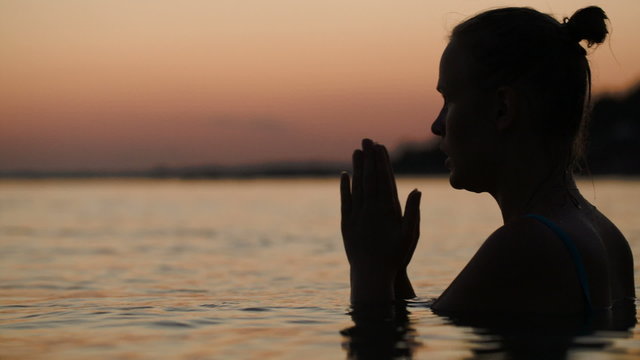 Woman in water praying or meditating