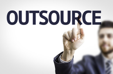 Business man pointing to transparent board with text: Outsource