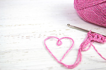 pink crochet background with yarn heart