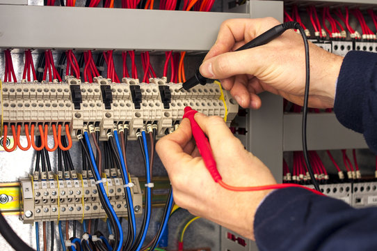 Electrician testing industrial panel