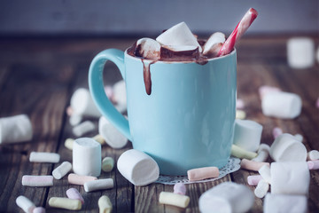 Mug filled with hot chocolate and marshmallow  and candy, toned