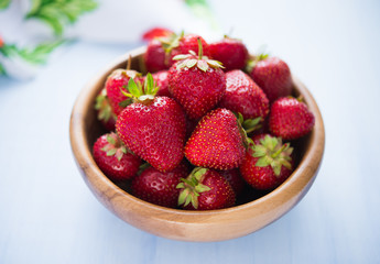 Wooden bowl filled with fresh ripe strawberries