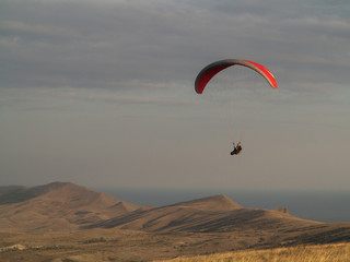 Paragliding. Hang glider flying over mountains.