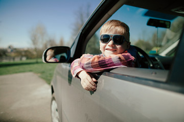 little boy driving fathers car