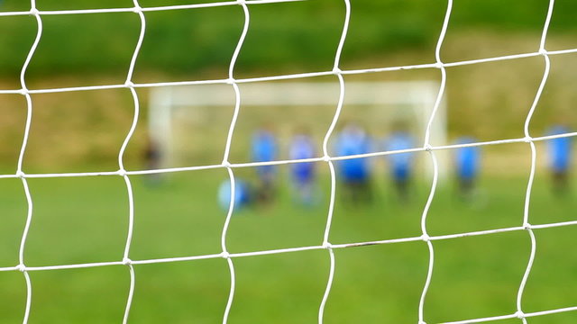 Children soccer game , focuse on the goal net