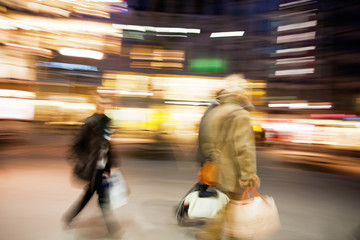 People walking down shopping street at dusk