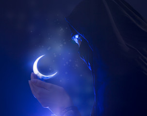 Beautiful young muslim girl holding a moon symbol, spirituality