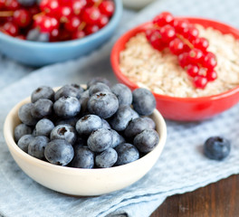 Blueberries, red currants nad cereals in bowls