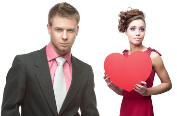 young sensual woman and handsome man holding red heart on white