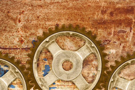 Ancient cog wheels against a rusty background