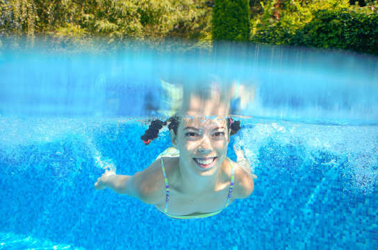 Happy active underwater child swims in pool, kids sport