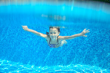 Happy active underwater child swims in pool, kids sport