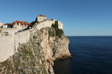 Fototapeta na wymiar Dubrovnik,the old wall, rocks and blue sea