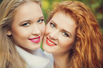 Two sisters in Fall yellow apple orchard. Autumn outside in colo