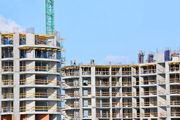 Crane and building construction site against blue sky