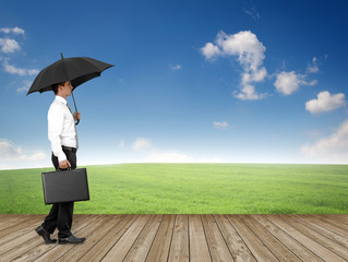 Mann mit Regenschirm in der Landschaft