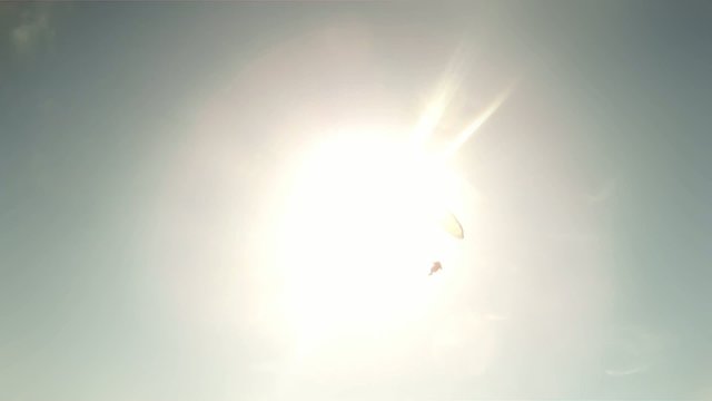 Paraglider against sun and blue sky