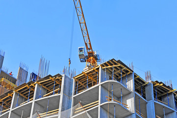 Crane and building construction site against blue sky