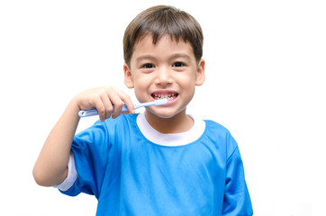 Little boy brushing teeth on white background